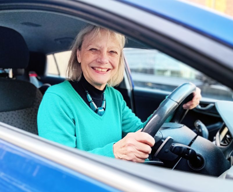 Female sitting in a car smiling